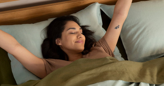 Woman laying on her back stretching and smiling