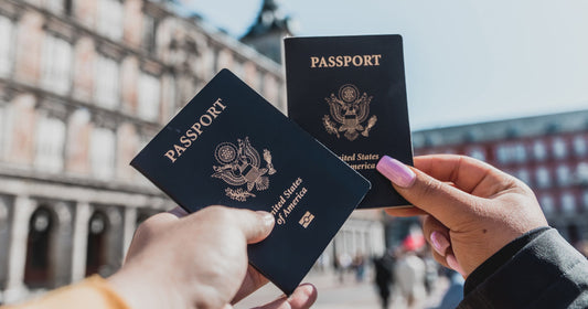 Picture of two passports being held up in front of a building
