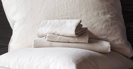Picture of white Tuft & Needle sheets folded on top of a Tuft & Needle pillow