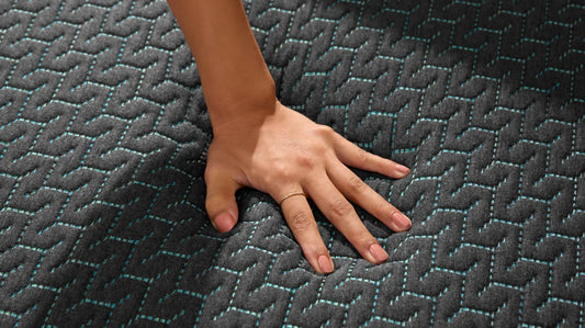 Hand pressing on a mattress