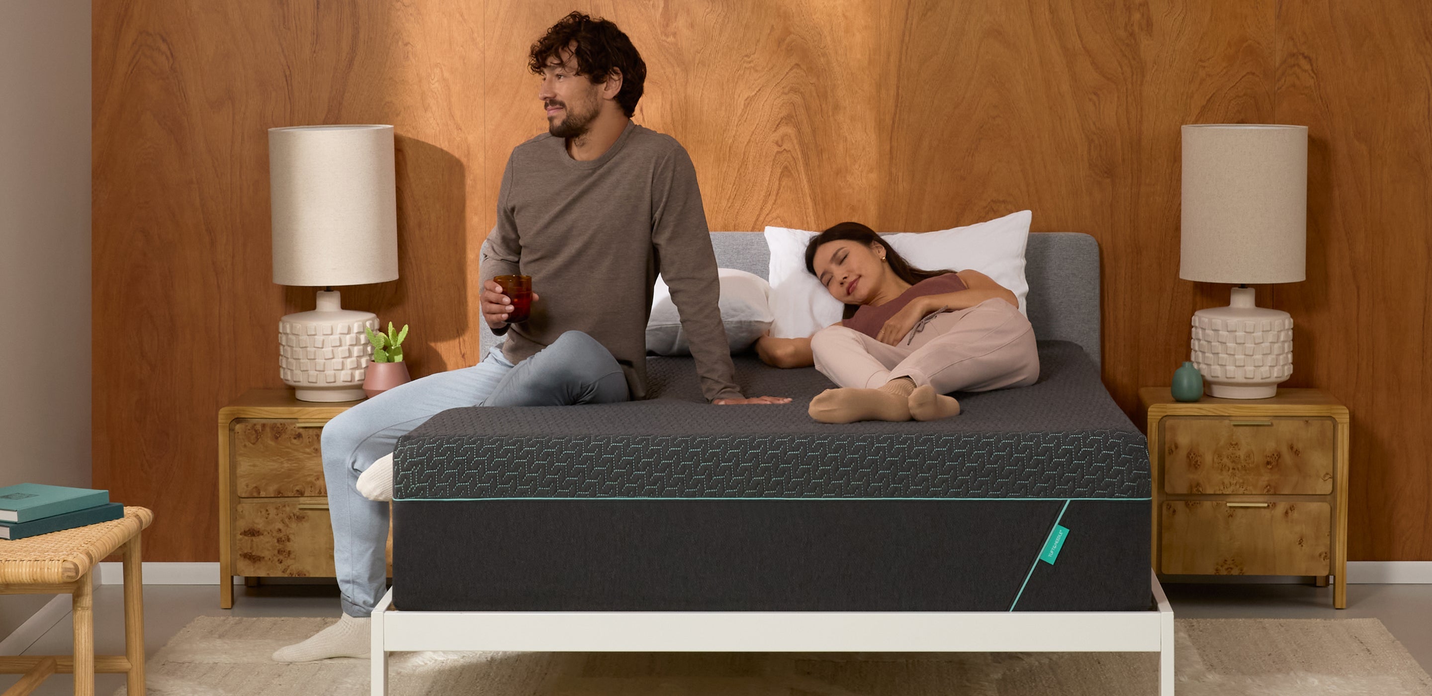 Man and woman on a tuft and needle mint hybrid mattress in a bedroom