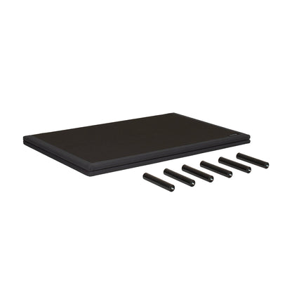 A black rectangular mat or pad shown on a plain white background, with five black cylindrical pieces placed in front of it.