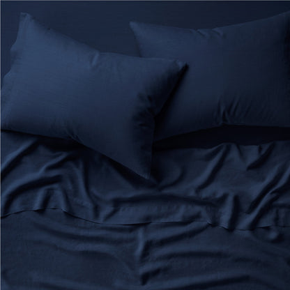 Two pillows on a bed dressed in the Tuft and Needle Hemp Pillowcase Set||color:midnight