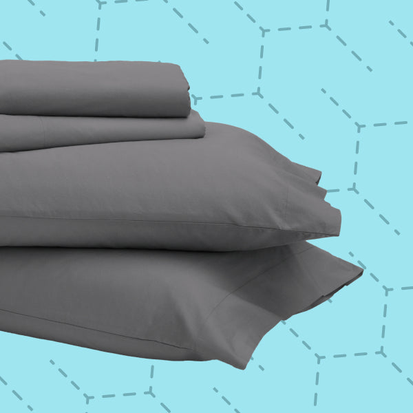 Stack of gray Tuft and Needle bed sheets on a blue background