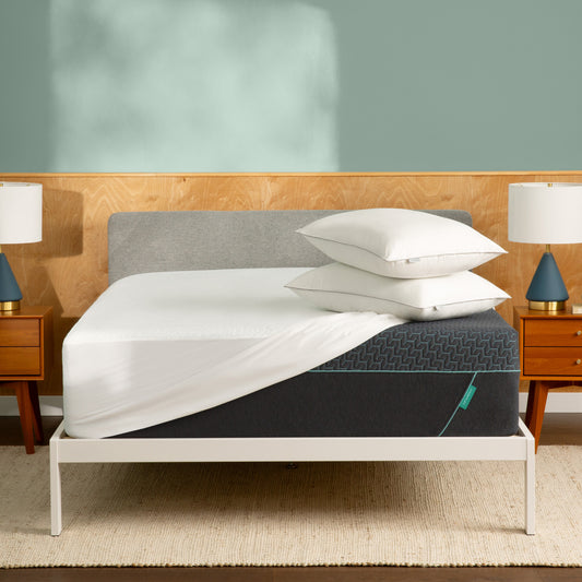 Tuft & Needle Bed with gray mattress, white sheets, and pillows in a bedroom setting.