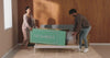 Couple unboxing a Tuft & Needle mattress and unrolling it on to their bed frame